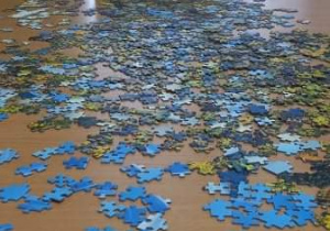Seniorzy z Klubu "Senior+" układają puzzle.